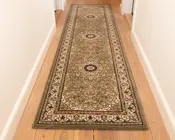 En lang, rektangulær løber med et indviklet blomster- og medaljonmønster i dæmpede jordfarver, herunder olivengrøn, beige og bordeaux. Tæppet har tre cirkulære medaljoner jævnt fordelt langs længden, omgivet af en detaljeret kant med snoede vinmønstre. Kanterne er pænt afsluttet, og tæppet ligger fladt på et lyst trægulv i en gang.