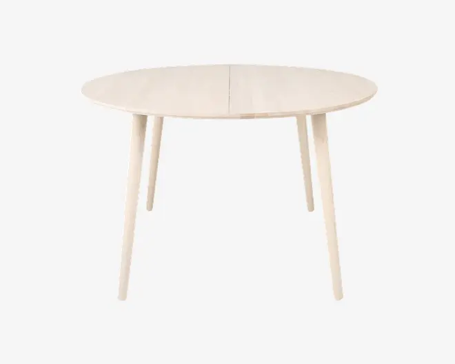 Bord i lyst træ med en glat, oval bordplade og fire let skråtstillede ben. Bordet har et minimalistisk design med rene linjer og en naturlig finish, hvilket giver det et moderne og let udtryk. Der er en diskret samling midt på bordpladen, hvilket antyder, at det muligvis kan udvides.