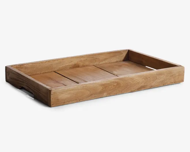 Rektangulær bakke i træ med høje kanter og et naturligt, ubehandlet udseende. Bunden består af tre brede træplanker, og siderne er solide, hvilket giver stabilitet. Træets årer er synlige, hvilket giver et rustikt og håndlavet præg. Der er udskårne håndtag i de korte sider for nem bæring.