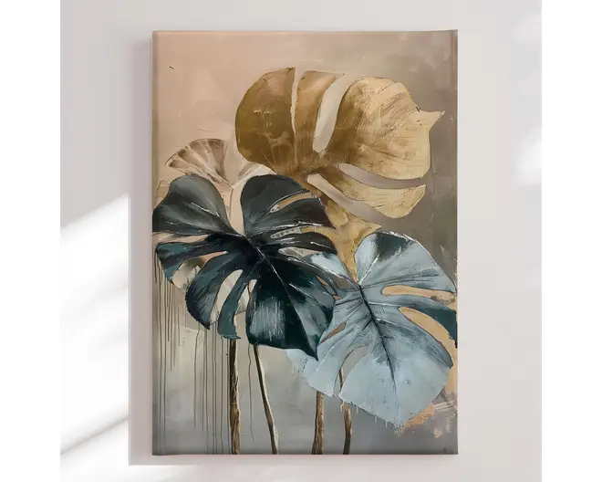Et lærredsmaleri med tre store, teksturerede monstera-blade. Bladene er malet i metallisk guld, dyb grøn og afdæmpede blå nuancer, med synlige penselstrøg og forhøjede detaljer, der giver et tredimensionelt udtryk. Baggrunden er en blød overgang af beige og grå, hvilket tilføjer et moderne og elegant præg. Der ses malingsdråber nederst, som understreger det kunstneriske, håndmalede udtryk.