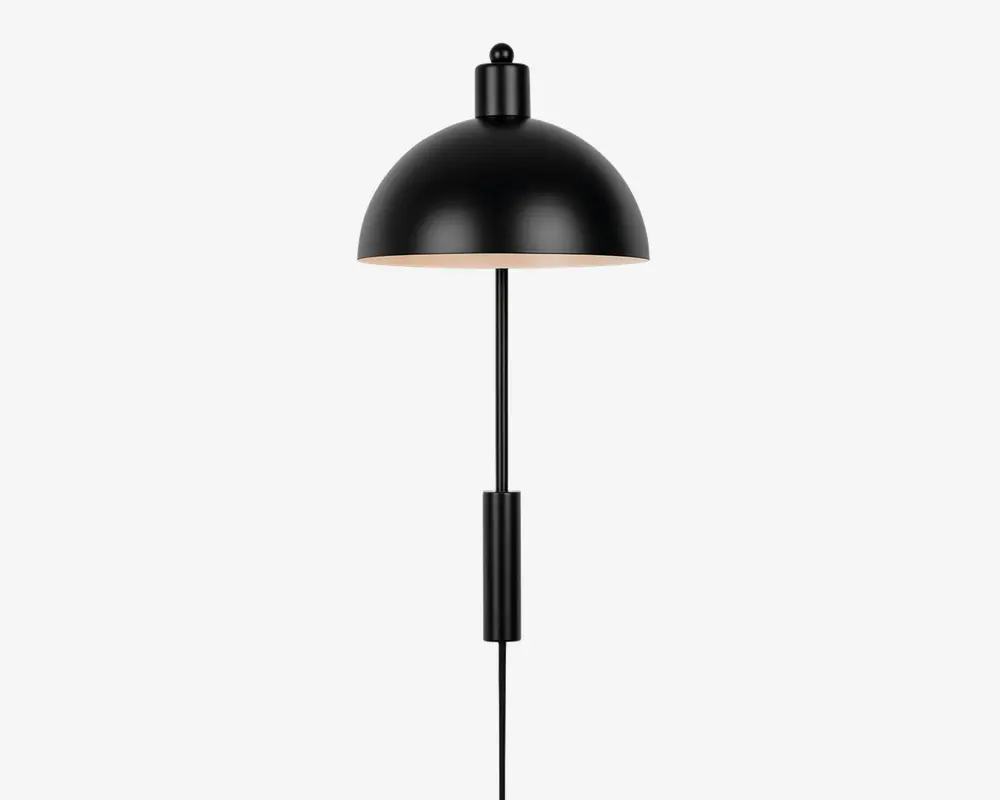 En moderne lampe med en mat sort, kuppelformet metalskærm med glat finish. Lampen har en slank, lodret kromstang og en matchende sort cylindrisk detalje nær bunden. Undersiden af skærmen er hvid, hvilket giver et blødt og diffust lys. Designet er minimalistisk og moderne, velegnet til forskellige indretninger.