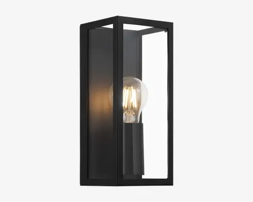 Rektangulær vægmonteret lampe med mat sort metalramme og klare glasplader på alle sider. Designet har en synlig standard fatning, hvilket gør det nemt at udskifte pæren og giver et moderne, industrielt udtryk. Lampen er åben i top og bund for direkte lysudsendelse og ventilation.