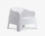 Moderne lænestol med en glat, mat hvid overflade. Stolen har en bred, buet ryg og integrerede armlæn for ekstra komfort. Designet er minimalistisk og støbt i ét stykke med let udsvungne ben og en let tilbagelænet siddeflade, velegnet til både indendørs og udendørs brug.
