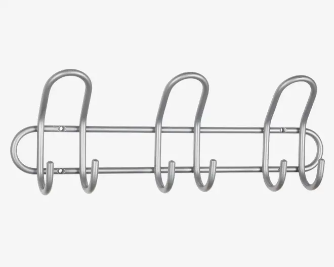 Væghængt stativ i sølvfarvet metal med tre store, buede kroge og seks mindre kroge nedenunder, alle fastgjort til to vandrette stænger. Designet er minimalistisk og moderne med afrundede kanter og en glat overflade. Stativet er fastgjort til væggen med synlige skruer i hver ende.