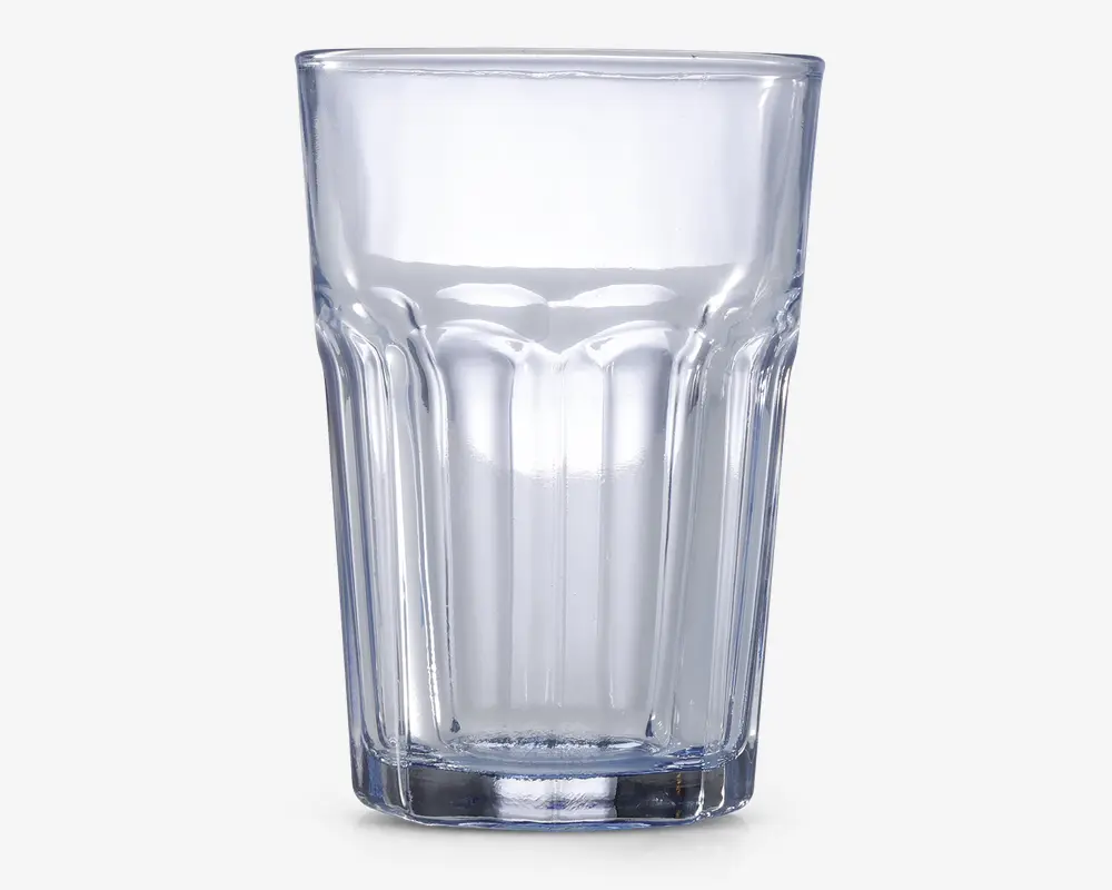 Klar glastumbler med tyk bund og lodrette riller på siderne for bedre greb. Glasset har en let konisk form, bredere foroven og smallere forneden, samt en glat kant for behagelig drikning.