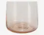 Nærbillede af den nederste halvdel af et transparent glas med et diskret lyserødt skær. Glasset har en glat, afrundet bund og lige sider samt en tyk bund for stabilitet. Overfladen er blank og uden mønstre eller dekorationer.