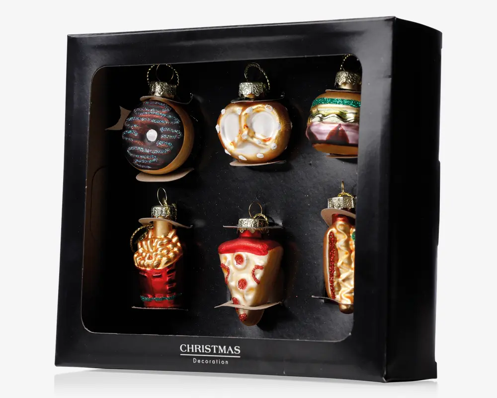 Sæt med seks julepynt i glas, formet og malet som populære fastfood-retter: en chokoladedonut med krymmel, en saltet pretzel, en burger med salat og tomat, en portion pommes frites, et stykke pepperoni-pizza og en hotdog med sennep. Hver pynt har en gylden top og ophæng, og sættet leveres i en sort gaveæske.