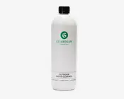 En høj, cylindrisk hvid flaske med sort skruelåg. Etiket har et grønt cirkulært logo med et 'G' og teksten 'GUARDIAN Furniture Care' i grønt. Under dette står der med sort tekst 'OUTDOOR WOOD CLEANER.' Nederst på etiketten står produktnavnet på flere sprog. Designet er minimalistisk og enkelt med tydelig, letlæselig tekst.