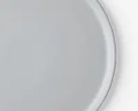 Et nærbillede af en enkel, rund, hvid tallerken med en glat, blank overflade og en let hævet kant. Tallerkenen har et minimalistisk design uden mønstre eller dekorationer.