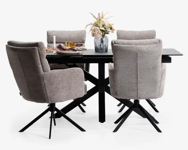 Et moderne spisesæt med et rektangulært sort bord med solidt krydsformet understel og seks polstrede stole. Stolene er betrukket med lysegråt stof, har høje rygge og sorte metalben med drejefunktion. Bordet er dækket med tallerkener, glas, et stearinlys og en dekorativ vase med blomster, hvilket skaber en indbydende og elegant spiseatmosfære.