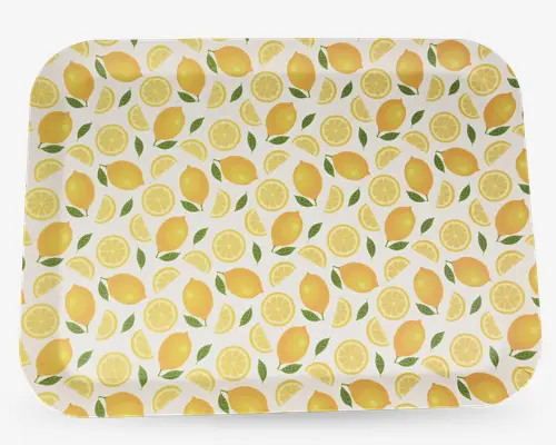 Rektangulær bakke med afrundede hjørner, dekoreret med et livligt mønster af hele citroner, citronskiver og grønne blade på hvid baggrund. Designet er frisk og sommerligt med gule og grønne nuancer, der giver et lyst og indbydende udtryk. Overfladen ser glat og blank ud.