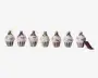 Sæt med seks ornamenter formet som cupcakes, hver med en metallisk bund i forskellige farver (grøn, lilla, guld, sølv, rød, blå) og toppet med en hvid, frosting-lignende dekoration. Hvert ornament har en lille løkke øverst til ophængning, og bundene har lodrette striber. Ornamenterne har en blank finish og et festligt udseende.