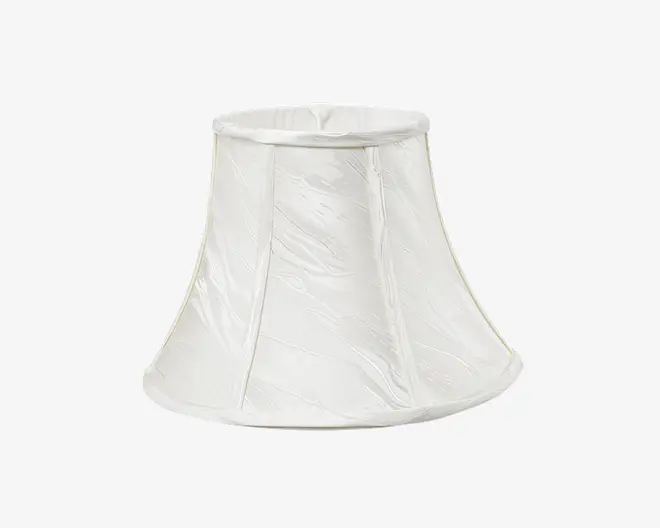 En hvid, klokkeformet lampeskærm med let udsvajet bund og smal top. Stoffet har en diskret, krøllet struktur og er forstærket med lodrette syninger, der giver form. Top- og bundkanterne er afsluttet med en glat kant for et elegant udtryk.