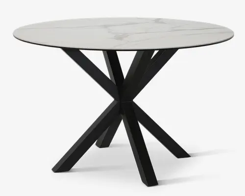 Rundt bord med en glat, hvid bordplade med marmoreffekt og diskrete grå årer. Basen består af fire skråtstillede, mat sorte metalben, der krydser hinanden i midten og skaber et moderne, geometrisk udtryk. Designet giver både stabilitet og et nutidigt look.