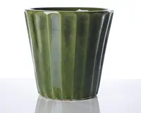 En blank, mørkegrøn keramisk beholder med let konisk cylindrisk form. Ydersiden har lodrette riflede riller, der giver et tekstureret, bølget udseende. Kanten er glat og let afrundet, og overfladen er reflekterende, hvilket fremhæver den dybe grønne farve.