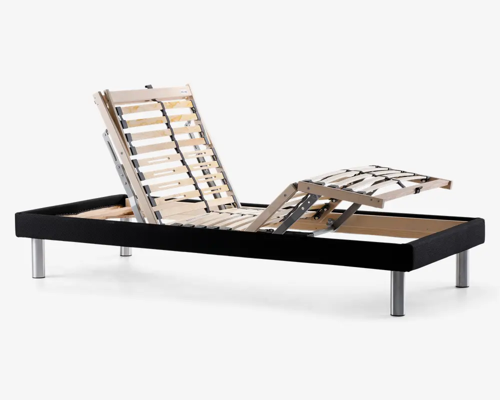 Justerbar sengebund med sort stoframme og sølvfarvede metalben. De lamellerede træsektioner er opdelt i tre zoner, så hoved-, ryg- og benområderne kan hæves eller sænkes individuelt for optimal komfort. Lamellerne er forstærket med sorte støttebånd for ekstra holdbarhed.