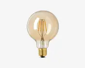 Rund, klar glaspære med synlig filament og en varm ravfarvet tone. Pæren har en standard skruefatning i metallisk guld. Filamentet er arrangeret i lodrette linjer, hvilket giver et vintage eller dekorativt udseende.