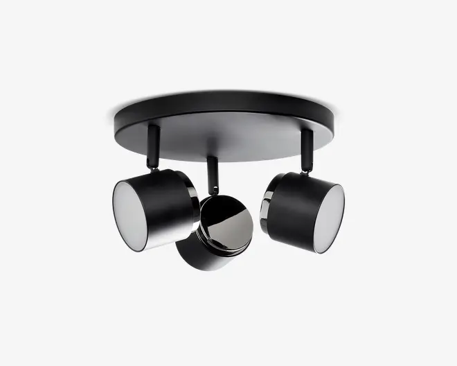 Moderne loftlampe med tre justerbare cylindriske spots, der er monteret på en rund base. Lampen har en mat sort finish med kromdetaljer omkring kanterne på hver spot. Spotsene kan drejes individuelt, så lyset kan rettes præcist, hvor det ønskes, hvilket gør lampen velegnet til både accent- og arbejdsbelysning.