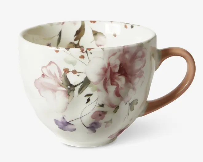 Porcelænskop med et fint blomsterdesign i lyserøde, lilla og grønne nuancer. Koppen har en rund form og en glat, blank overflade. Hanken er malet i en blød rosa farve, som matcher blomsterdekorationen. Indersiden har også diskrete blomsterdetaljer, hvilket giver et sammenhængende og elegant udtryk.