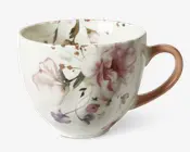 Porcelænskop med et fint blomsterdesign i lyserøde, lilla og grønne nuancer. Koppen har en rund form og en glat, blank overflade. Hanken er malet i en blød rosa farve, som matcher blomsterdekorationen. Indersiden har også diskrete blomsterdetaljer, hvilket giver et sammenhængende og elegant udtryk.