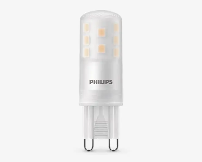 En kompakt LED-pære med cylindrisk form, mat finish og synlige interne LED-chips arrangeret i to lodrette rækker. Soklen er en G9-stik med to ben, hvilket gør den nem at installere i kompatible fatninger. Pæren har 'PHILIPS' trykt på siden, hvilket angiver producenten.
