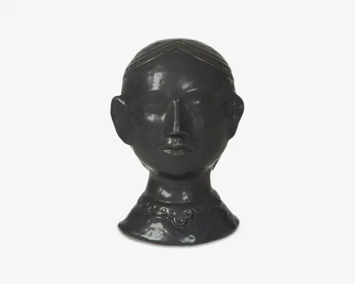 En blank, mørk buste med detaljeret, tekstureret hår og et mønstret design langs hårgrænsen. Ørerne er markante og veldefinerede, og halsen er udsmykket med en hævet, dekorativ krave med cirkulære og buede udsmykninger. Overfladen er glat og reflekterende, hvilket giver skulpturen et poleret udtryk.