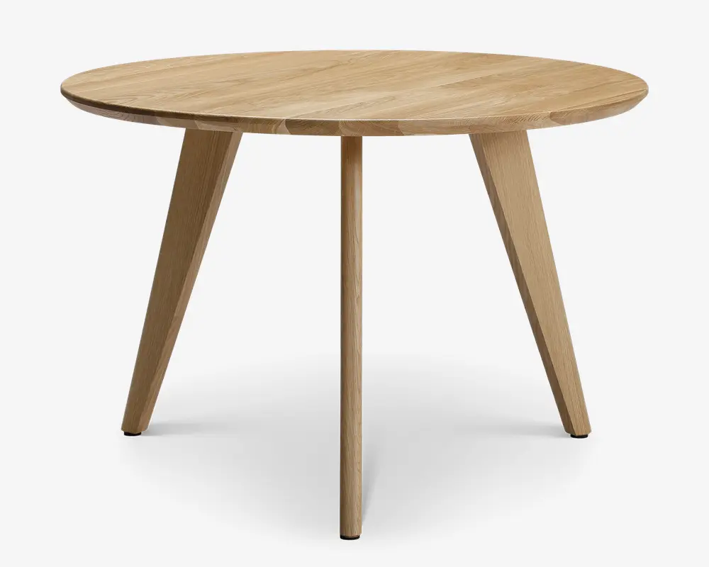 Rundt bord med en glat, lys træfinish. Har et minimalistisk design med tre skråtstillede ben for stabilitet. Bordpladen har et diskret træmønster, og kanterne er let affasede for et elegant udtryk. Benene er tilspidsede, hvilket giver bordet et moderne og stilrent udseende.