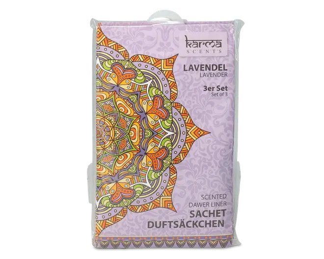Rektangulær pakke med lys lilla baggrund og et stort, farverigt mandala-mønster i orange, grønne og lilla nuancer på venstre side. Emballagen viser mærket 'Karma Scents' øverst til højre og angiver, at produktet er et sæt med tre lavendelduftende duftposer. Teksten er trykt på både engelsk og tysk, og det samlede design har et dekorativt og beroligende udtryk.