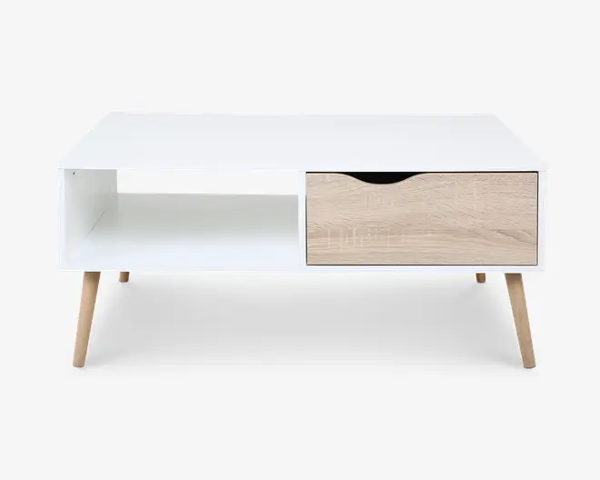 Rektangulært bord med hvid top og korpus, fire skråtstillede ben i lyst træ. Bordet har en åben hylde i venstre side og en enkelt skuffe til højre med lys træfinish og et buet udskåret greb for nem åbning.