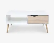 Rektangulært bord med hvid top og korpus, fire skråtstillede ben i lyst træ. Bordet har en åben hylde i venstre side og en enkelt skuffe til højre med lys træfinish og et buet udskåret greb for nem åbning.