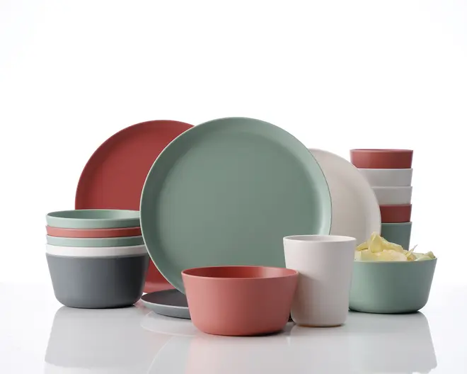 Et sæt service med tallerkener, skåle og kopper i et moderne, minimalistisk design. Delene er lavet af et glat materiale med mat finish og har en koordineret farvepalet i støvet grøn, rosa, blød hvid og mørkegrå. Sættet indeholder store og små tallerkener, dybe og lave skåle samt kopper, som alle kan stables for nem opbevaring. Kanterne er let afrundede, og det samlede udtryk er moderne og stilrent.