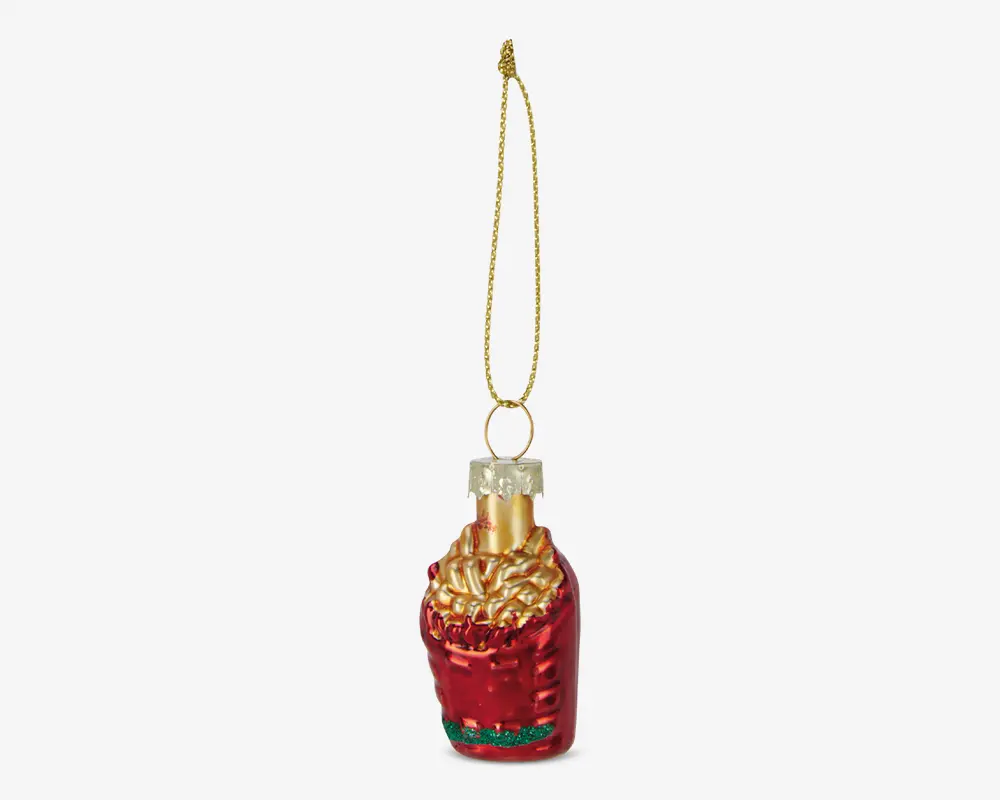 Et glitrende ornament formet som en rød pommes frites-bakke med gyldne fritter, der stikker op fra toppen. Ornamentet har en metallisk finish og er udstyret med en gylden hætte og en glitrende guldfarvet snor til ophæng. Der er grønne detaljer nederst på bakken og realistisk tekstur på fritterne.