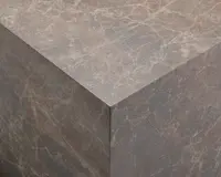 Nærbillede af en kube med en brun marmorlignende overflade. Teksturen har naturlige årer i lysere nuancer, hvilket giver et realistisk stenlook. Kanterne er skarpe, og overfladen ser glat og mat ud.