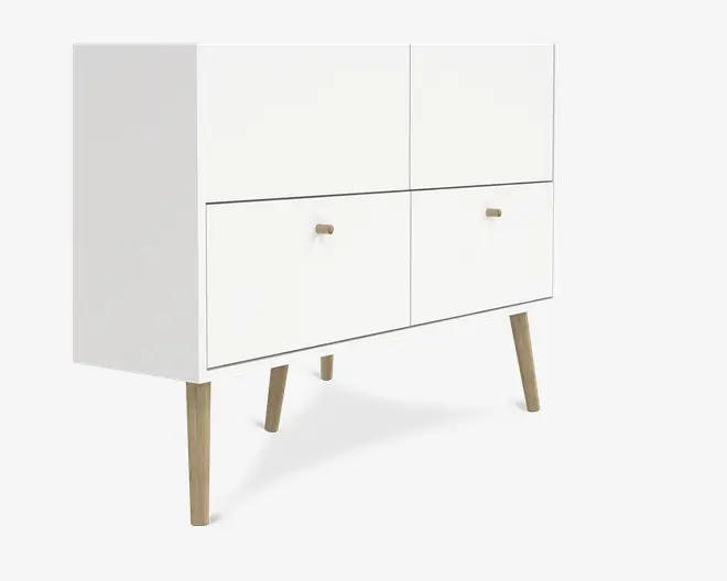 Rektangulært skab med minimalistisk design, mat hvid finish og fire rum. De nederste to rum har små, runde trægreb til åbning. Skabet står på fire skråtstillede ben i lyst træ, hvilket giver et moderne, skandinavisk udtryk.