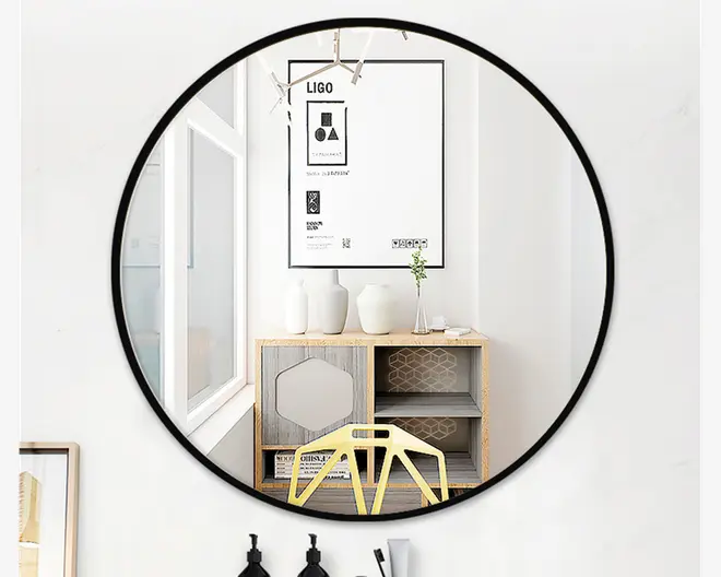 Rund vægspejl med en tynd sort metalramme. Spejlet har et moderne, minimalistisk design og giver en klar refleksion. Rammen er slank og diskret, hvilket gør spejlet velegnet til forskellige indretninger. Spejlet ser ud til at være mellemstort til stort og egner sig godt til brug i stue, soveværelse eller entré.