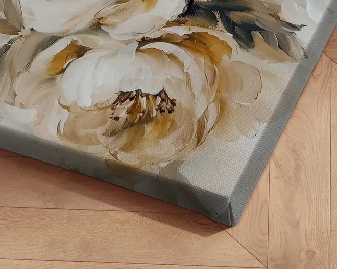 Nærbillede af et lærredsprint med et tekstureret, håndmalet blomsterdesign i nuancer af creme, beige og guld. Penselstrøgene er tydelige og giver kunstværket et tredimensionelt, kunstnerisk udtryk. Lærredet er stramt spændt omkring en træramme med skarpe, rene kanter. Baggrunden viser et trægulv med en lys, naturlig finish.
