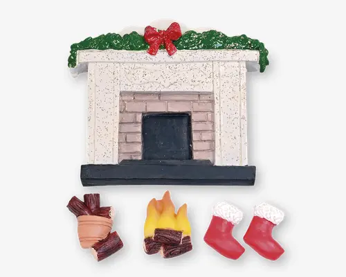 En dekorativ miniaturepejs med hvid og murstensdesign, pyntet med grøn guirlande og en rød sløjfe. Sættet indeholder separate dele: en lille bunke brænde, et bål med gule og orange flammer samt to røde julestrømper med hvid kant. Detaljerne giver en hyggelig og festlig julestemning.