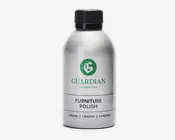 En sølvfarvet flaske med sort skruelåg, der har et grønt 'G'-logo og mærket 'Guardian Furniture Care' på etiketten. Etiketten viser også produktnavnet 'Furniture Polish' med fed sort skrift samt oversættelser på dansk, norsk og tysk. Flasken har et stilrent, moderne design og ser ud til at være lavet af metal eller metallisk plast.