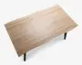 Bordplade i lyst trælook med buet levende kant foran, understøttet af slanke sorte ben.