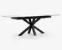 Rektangulært bord med en glat, hvid marmoreret eller marmorlignende bordplade og en markant sort metalbase. Basen har et kantet, stjerneformet design med flere ben, der stråler ud fra et centralt punkt, hvilket giver både stabilitet og et moderne, skulpturelt udtryk. Bordet har rene linjer og en nutidig stil.