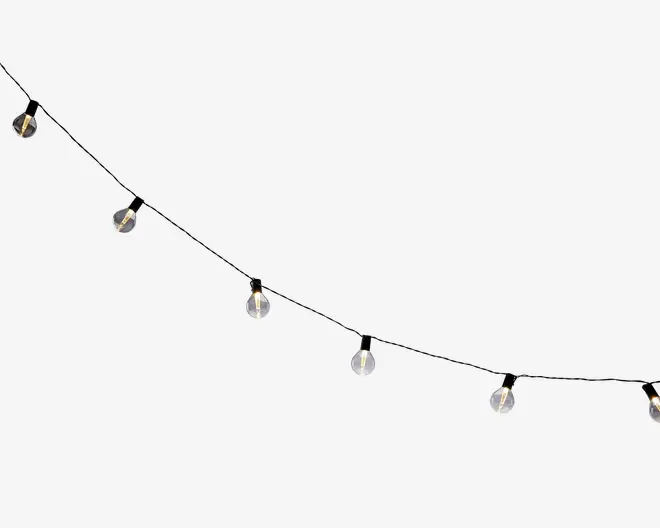 En lyskæde med dekorative lys, hvor hver pære er dækket af en klar, kubeformet skærm. Lysene er jævnt fordelt langs en tynd, mørk ledning, og hver pære udsender et varmt hvidt skær. Designet er moderne og minimalistisk, velegnet til både indendørs og udendørs brug, og giver et diskret og stilfuldt lys til ethvert rum.