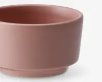En rund skål med mat finish i en afdæmpet lyserød farve. Skålen har en glat overflade med en let tyk kant og en diskret forhøjet bund, hvilket giver et moderne og minimalistisk udtryk.