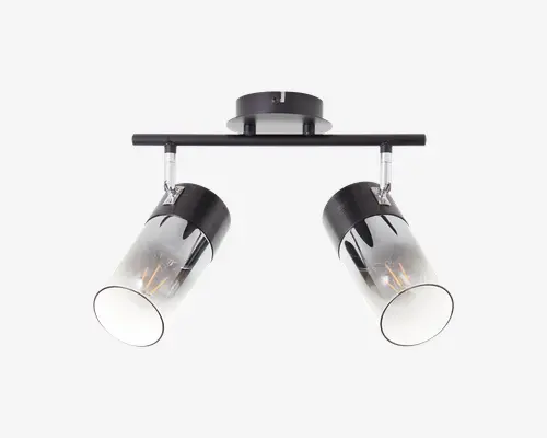 Loftmonteret armatur med to justerbare cylindriske spotlys. Hver spot har en sort metalbase og en klar glasafskærmning med et dekorativt sort drypmønster øverst. Armaturet er fastgjort til en rektangulær metalstang, hvilket gør det muligt at vinkle spotlysene efter behov. Moderne og stilrent design, der passer til nutidige indretninger.