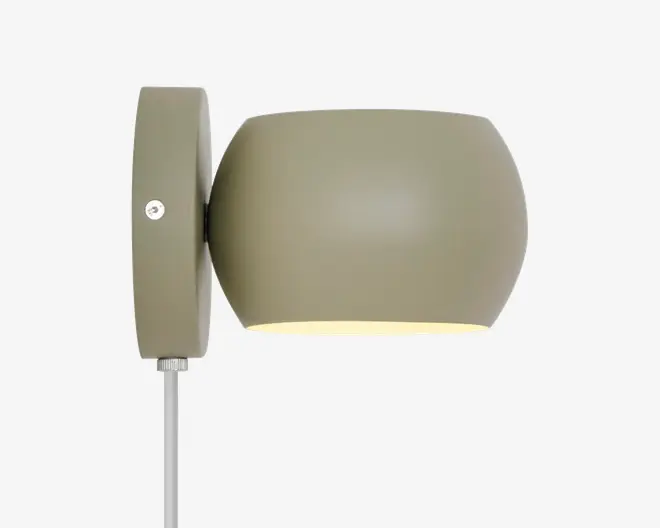 Væghængt lampe med mat olivengrøn finish og en rund, trommeformet skærm. Lampen har et enkelt, moderne design med en synlig skrue på monteringspladen og en ledning, der går ud fra bunden. Skærmen leder lyset nedad og giver en fokuseret belysning.