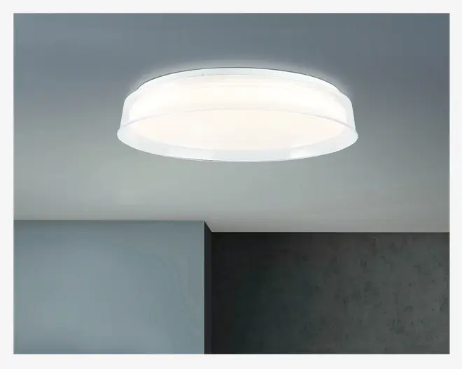 Et moderne, rundt loftarmatur med en hvid, mat skærm, der spreder lyset jævnt. Armaturet har et lavt design, hvilket gør det velegnet til rum med lav loftshøjde. Kanterne er let hævede, hvilket giver et diskret lagdelt udseende. Lyset udsender en blød, klar glød, ideel til generel rumbelysning.