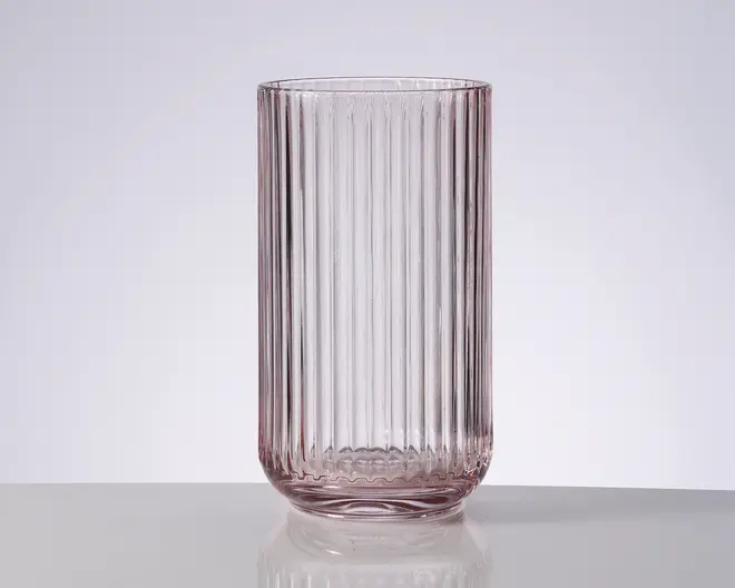 Højt, klart glas med lodrette riller, let afrundet bund og en svag rosa farvetone.