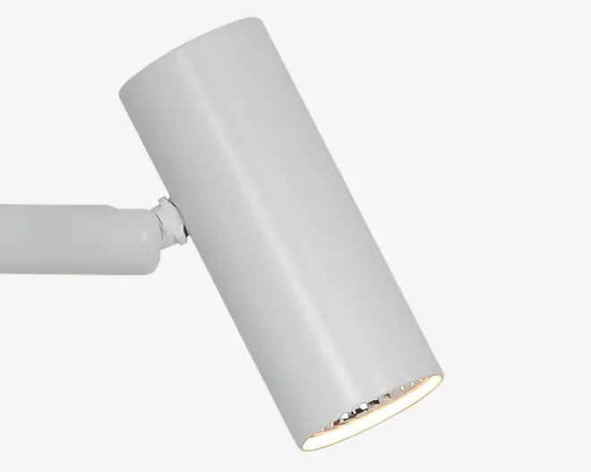 Hvid cylindrisk justerbar armatur med langt afrundet hus, skråt hoved og en synlig reflekterende åbning i enden.