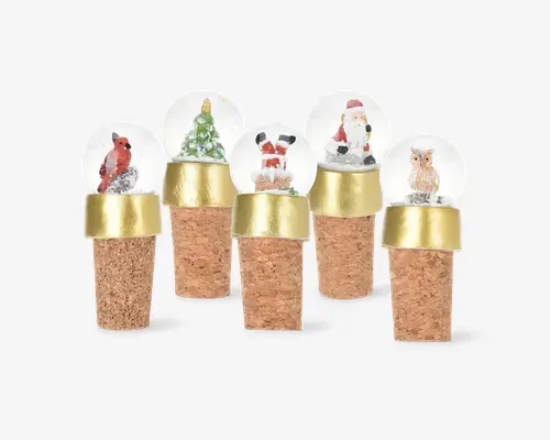 Sæt med fem flaskestoppere med korkbund og dekorative glastoppe, hver med en miniature-snekugle. Motiverne inkluderer en rød fugl, et juletræ, julemanden, en ugle og julemandens ben, der går ned i en skorsten. Hver prop har et guldfarvet bånd mellem korken og glaskuglen.