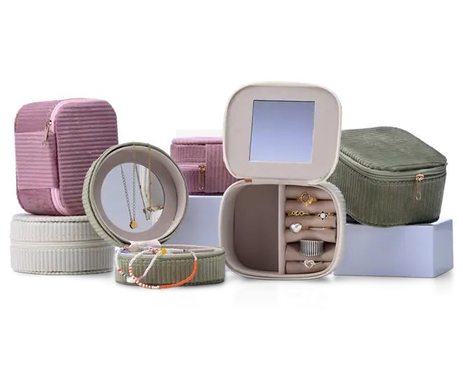 Assorterede smykkeskrin i pastel farver, herunder runde og firkantede etuier med lynlås, en rektangulær organizer med spejl samt små rum til ringe, halskæder og armbånd.