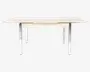 Rektangulært bord med en lys træbordplade og lige, polerede metalben. Bordpladen har en glat overflade og let skrå kanter, hvilket giver et moderne og minimalistisk udtryk. Benene er placeret i hjørnerne, hvilket giver stabilitet og et åbent, rent udseende under bordet.
